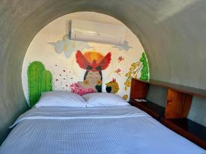 a bedroom with a bed with a painting on the wall at ChangoMango in La Ventana +23 photos
