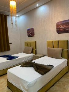 a room with two beds and a chandelier at maison de bonheur 2 in Tafraout