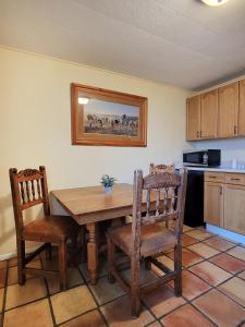a kitchen with a wooden table and two chairs at La Veta Inn in La Veta
