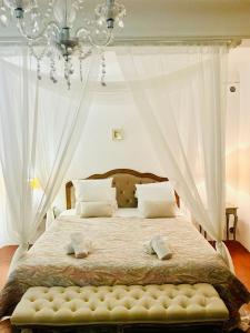 a bedroom with a large bed with a chandelier at Maison Barnoin-Chambres et villas au calme proche Nice in Bouyon +85 photos
