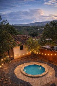 a small swimming pool in a yard with lights at Aura Hotel Parque Barichara By Infinity in Barichara
