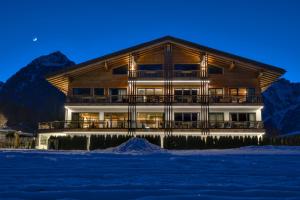 a large wooden building with snow in front of it at Wagner's Aparthotel in Pertisau