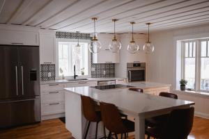 a kitchen with a table and some chairs in it at Chalet l'Intemporel - St Lawrence View in Notre-Dame-du-Portage