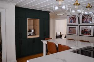 a kitchen with green cabinets and a white table and chairs at Chalet l'Intemporel - St Lawrence View in Notre-Dame-du-Portage