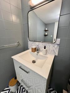a bathroom with a white sink and a mirror at Montbel'appart Studio Central tout équipé in Montbéliard