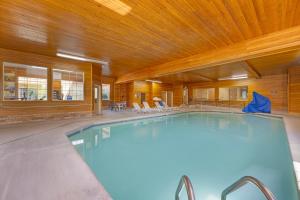 a swimming pool in a building with a wooden ceiling at Comfort Suites Salem in Salem
