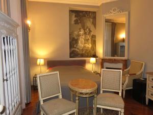 a bedroom with a bed with two chairs and a table at Hotel Windsor Home in Paris