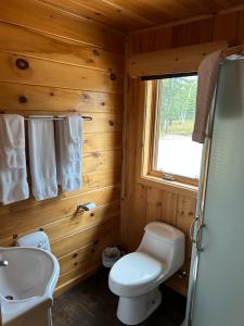 a bathroom with a white toilet and a sink at Les Chalets du Lac Serein (Milot) in Saint Ludger de Milot +43 photos