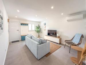 a living room with a couch and a television at Alma do Mar - Alma Nossa in Montijo