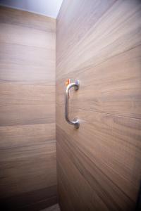 eine Tür mit einem Metallgriff an einer Holzwand in der Unterkunft Hotel 10 Joinville in Joinville + 67 Fotos