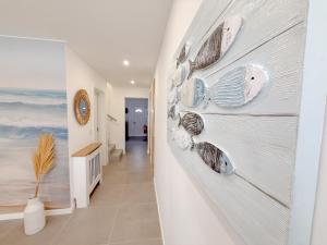 a hallway with a wall with seashells on it at Alma do Mar - Alma Nossa in Montijo