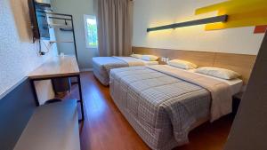ein Hotelzimmer mit zwei Betten in einem Zimmer in der Unterkunft Hotel 10 Joinville in Joinville