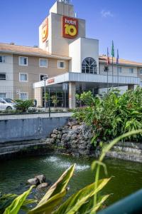 ein Hotel mit einem Teich vor einem Gebäude in der Unterkunft Hotel 10 Joinville in Joinville