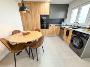 a kitchen with a table and chairs and a washing machine at Alma do Mar - Alma Nossa in Montijo