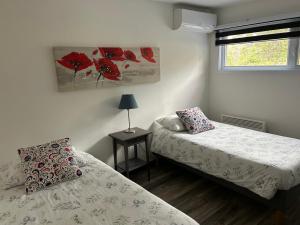 a bedroom with two beds and a window at Les Chalets du Lac Serein --Serein-- in Saint Ludger de Milot