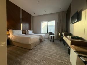 a hotel room with two beds and a window at Afaq Royal Almassar Hotel ex Hayah Al Iman in Mecca