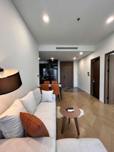 a living room with a white couch and a table at Clasio - Lumiere Riverside in Ho Chi Minh City