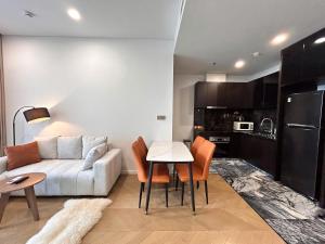 a living room with a white couch and a table at Clasio - Lumiere Riverside in Ho Chi Minh City