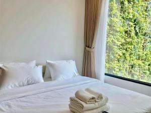 a bed with two towels on it with a window at Clasio - Lumiere Riverside in Ho Chi Minh City +1 photo
