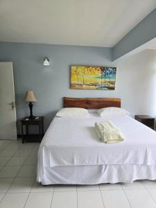 a bedroom with a white bed and a painting on the wall at The Gardens in Kingston +35 photos