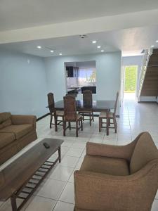 a living room with a couch and a table and chairs at The Gardens in Kingston