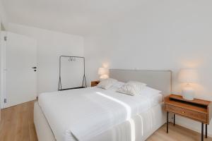a white bed with two pillows on it in a bedroom at Fiorea Apartment - Pula City Center With Private Garage Parking in Pula +38 photos