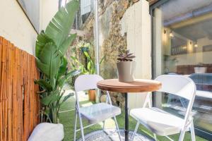 a table and chairs on a balcony with plants at Les Deux Clefs in Mont-de-Marsan
