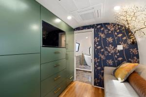 a living room with green cabinets and a couch at Airstream w Bathtub, River, & Hot Tub in Pisgah Forest