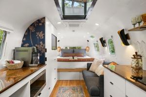 a tiny house with a bedroom and a bed at Luxury Airstream w hot tub, king bed, & grill in Pisgah Forest