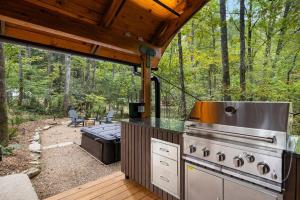 a outdoor kitchen with a grill and a grill at Luxury Airstream w hot tub, king bed, & grill in Pisgah Forest +37 photos