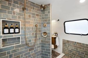 a bathroom with a shower with bottles of wine at Airstream w Bathtub, River, & Hot Tub in Pisgah Forest +35 photos