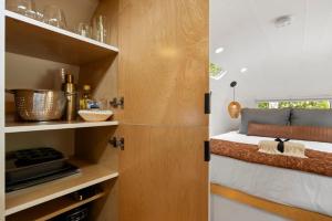 a small kitchen with a bed in a tiny house at Luxury Airstream w hot tub, king bed, & grill in Pisgah Forest