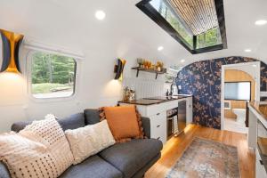 a living room with a couch and a kitchen at Luxury Airstream w hot tub, king bed, & grill in Pisgah Forest