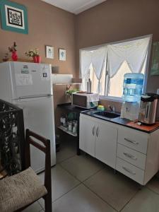a kitchen with a white refrigerator and a sink at Espacio Verde in Salta