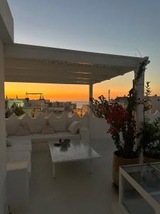 a living room with a white couch and a table at Riad Olivia in Asilah