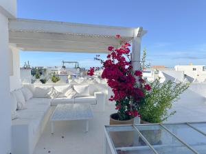 a living room with a couch and flowers on a roof at Riad Olivia in Asilah