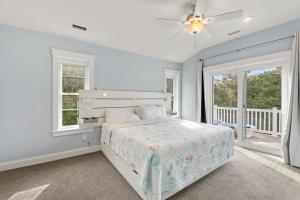 a white bedroom with a bed and windows at Wax Turtle in Southern Shores +53 photos