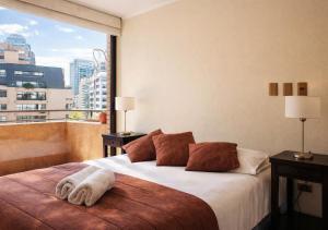 a bedroom with a large bed with a large window at Apartamentos Costanera Centre in Santiago