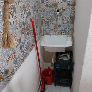 a small bathroom with a sink and a red mop at Espaço familiar in Saquarema