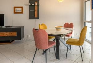 a dining room with a table and chairs at REF 321 - LARMOR PLAGE appartement type 3 vue mer in Larmor-Plage +4 photos