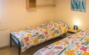 a bedroom with a bed with a floral bedspread at REF 321 - LARMOR PLAGE appartement type 3 vue mer in Larmor-Plage
