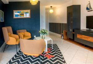 a living room with a table and chairs and a tv at REF 321 - LARMOR PLAGE appartement type 3 vue mer in Larmor-Plage