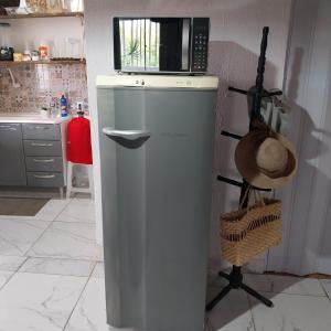 a small refrigerator in a kitchen with a microwave at Espaço familiar in Saquarema