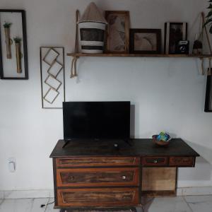 a television on a wooden dresser in a room at Espaço familiar in Saquarema