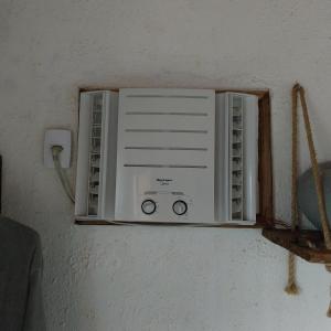 a white air conditioner in a room with a wall at Espaço familiar in Saquarema +8 photos