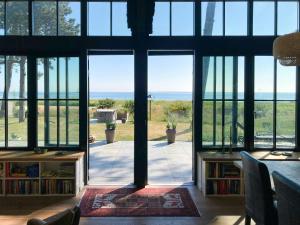 a room with a view of the ocean through windows at Beach Villa With Private Pier In Hou in Odder