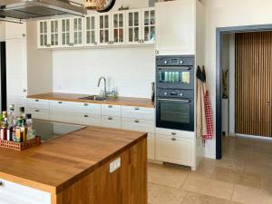 a kitchen with white cabinets and a stove top oven at Beach Villa With Private Pier In Hou in Odder
