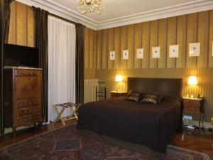 a bedroom with a bed and a television on a wall at Hotel Windsor Home in Paris