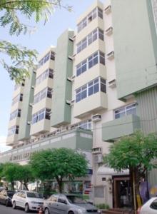 un gran edificio con coches estacionados frente a él en Hotel Imperial, en Mossoró