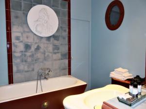 a bathroom with a bath tub and a sink at Hotel Windsor Home in Paris +54 photos